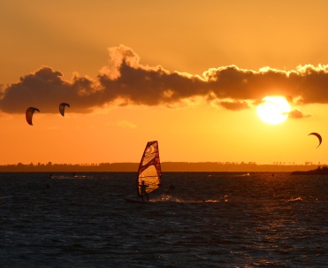 Żagle na tle zachodzącego nieba.